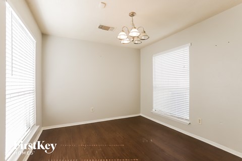 a bedroom with wood floors and white walls and a large window