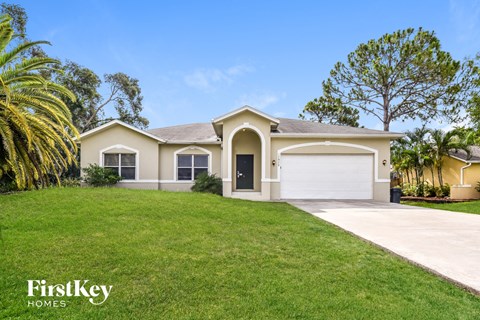 a beige house with a lawn and a garage door