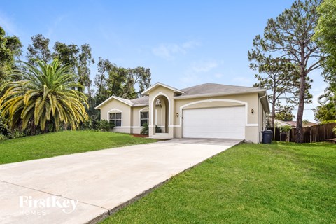 a beige house with a driveway and a garage door