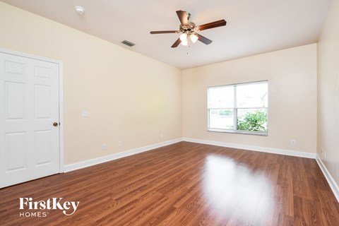 a living room with hardwood floors and a ceiling fan