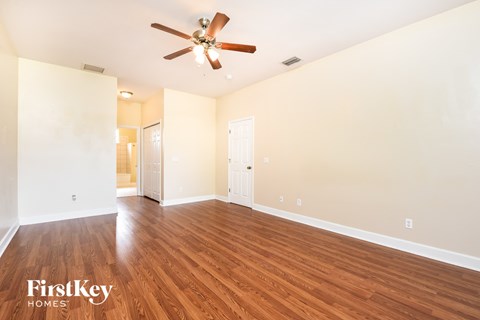 a living room with wood floors and a ceiling fan