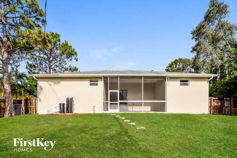 a small yellow house with a lawn and a tree