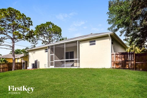 a home with a lawn and a fence in front of it