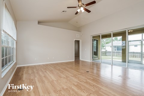 A room with a ceiling fan and wooden flooring.
