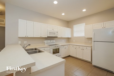 A kitchen with white cabinets and appliances.