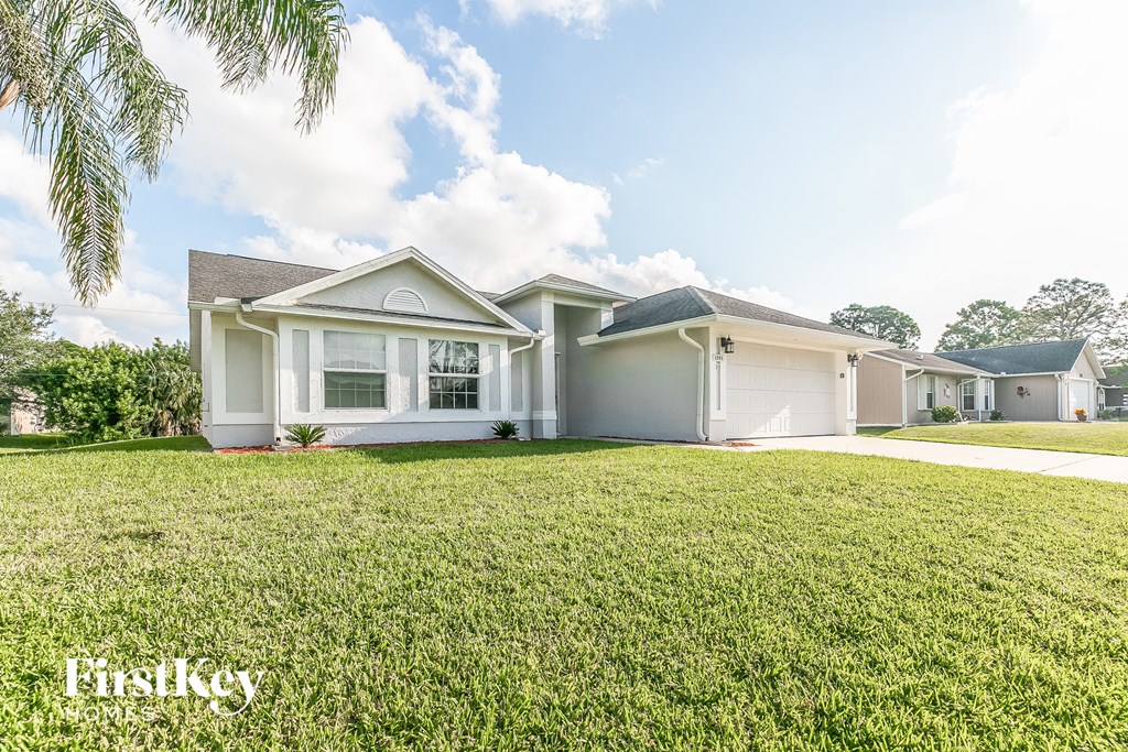 a white house with a grassy lawn in front of it