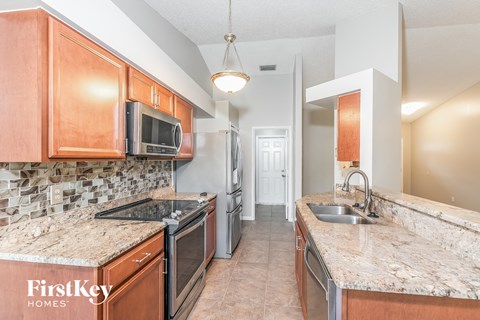a kitchen with wood cabinets and granite counter tops and stainless steel appliances