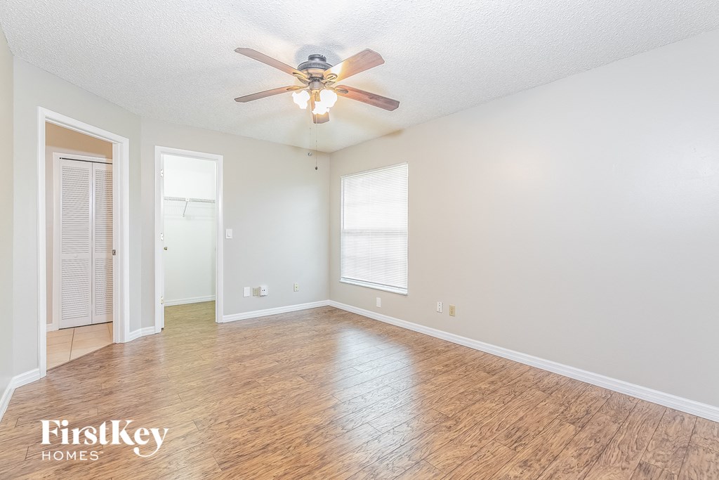 a living room with wood floors and a ceiling fan