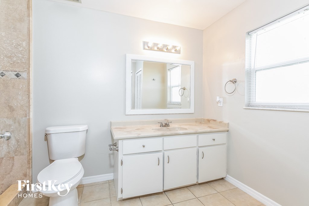 a bathroom with a toilet and a sink and a mirror