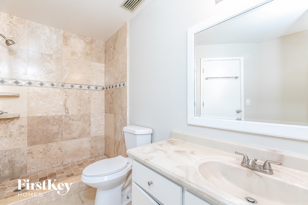 a bathroom with a sink toilet and a mirror