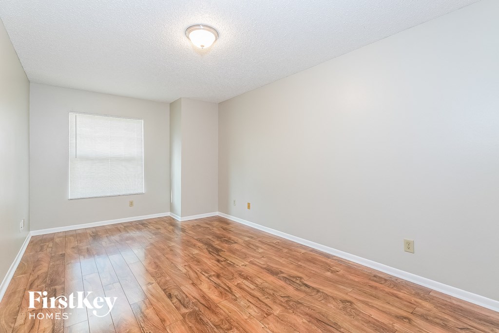 a spacious living room with hardwood floors and a window