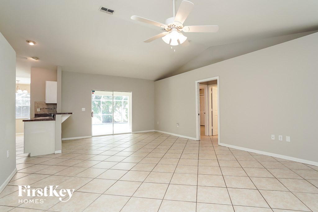A spacious room with a ceiling fan and tiled flooring.