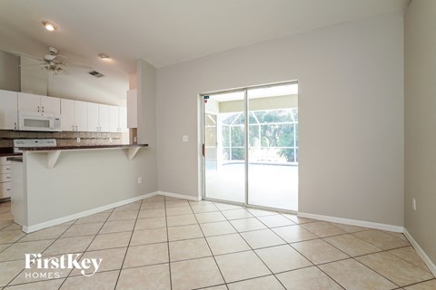 A kitchen with a tile floor and a sliding glass door leading to a backyard.