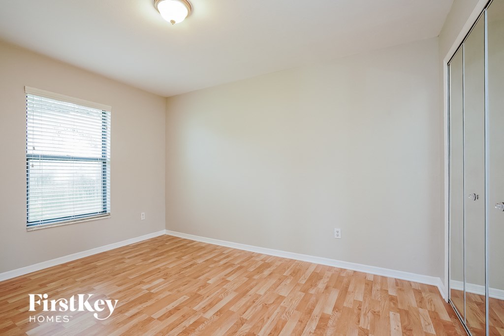 A room with wooden flooring and a sliding glass door.