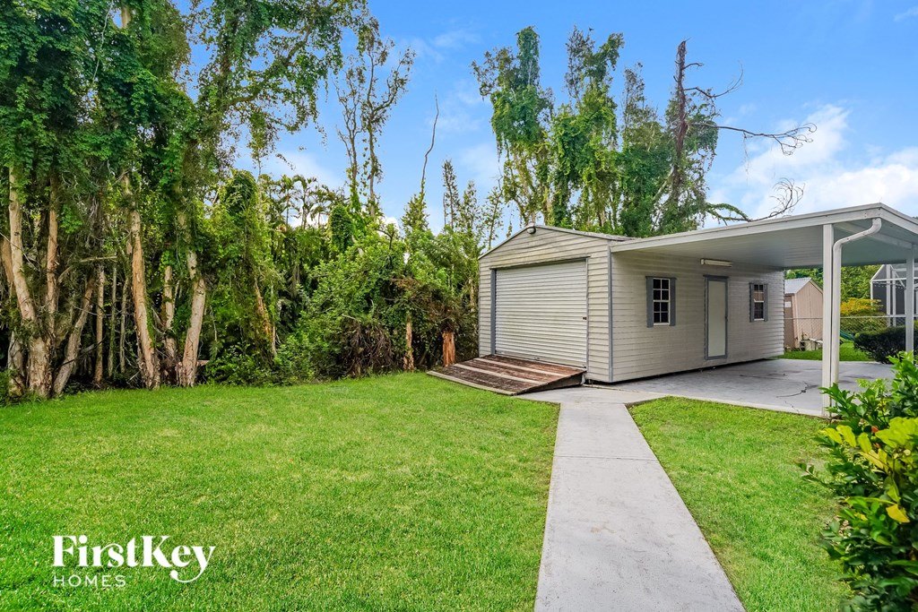 A house with a well-maintained lawn and trees in the background.