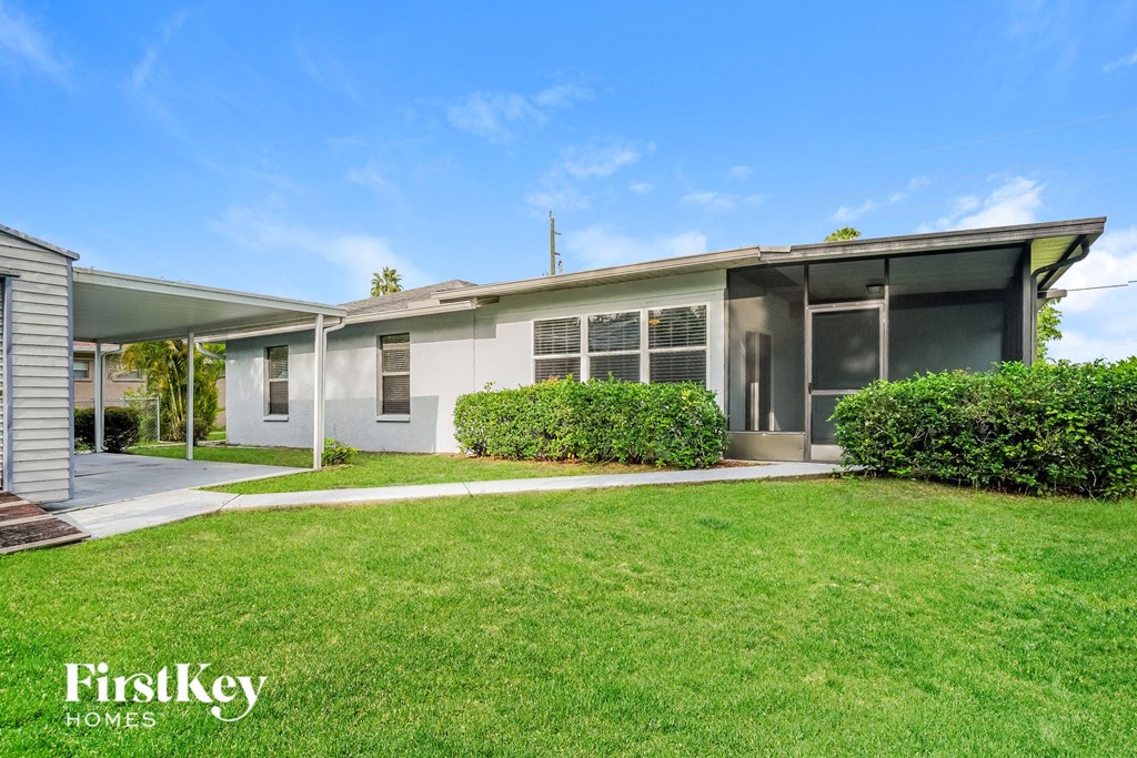 A house with a well-maintained lawn and a clear blue sky above.