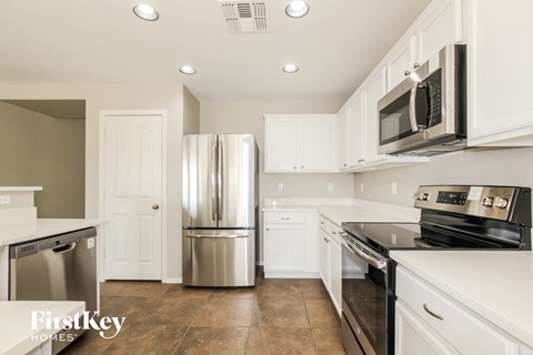 A kitchen with white cabinets and stainless steel appliances.