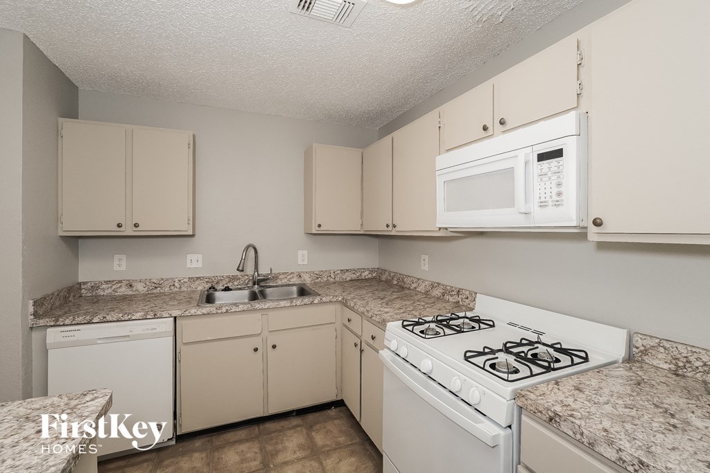a kitchen with white appliances and granite counter tops