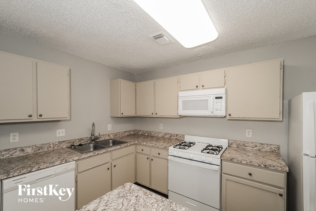 a kitchen with white appliances and granite counter tops