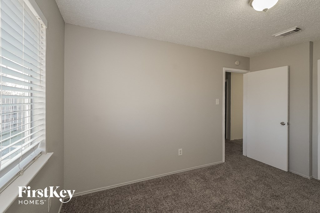a bedroom with a large window and a door to a closet