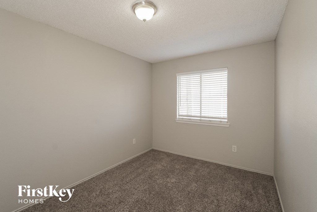a bedroom with a carpeted floor and a window