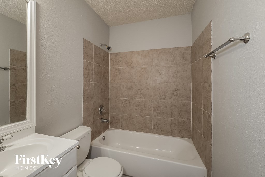 a white bathroom with a tub and a toilet and a sink
