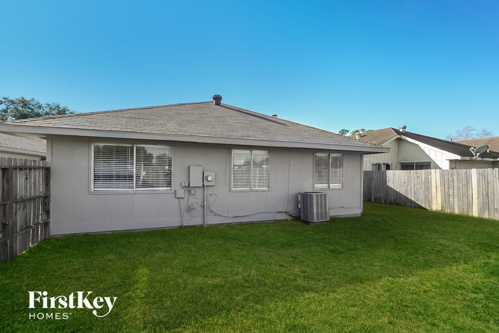 a backyard with a white house and a grass yard