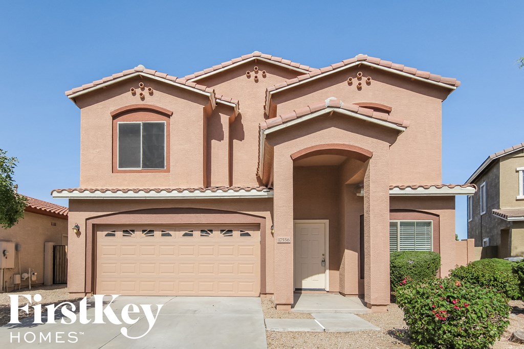 a pink house with a garage door in front of it