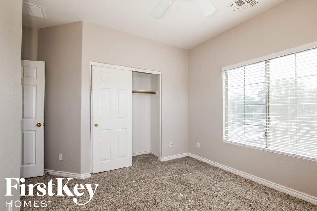 a bedroom with a closet and a door and a window