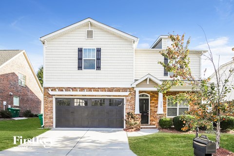 a white house with a black garage door
