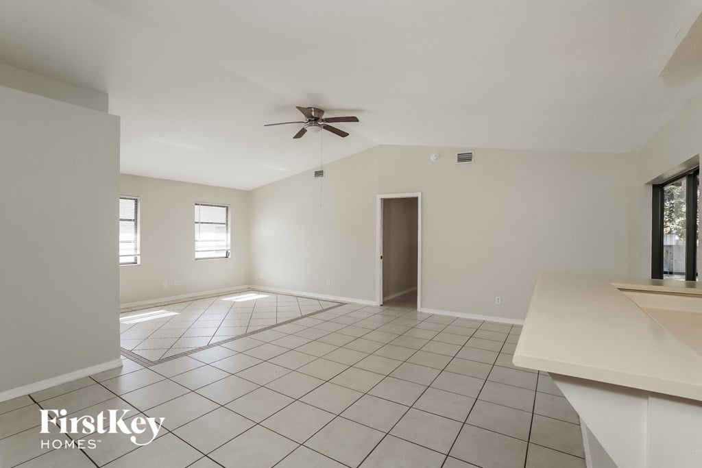 A spacious room with a ceiling fan and tiled flooring.