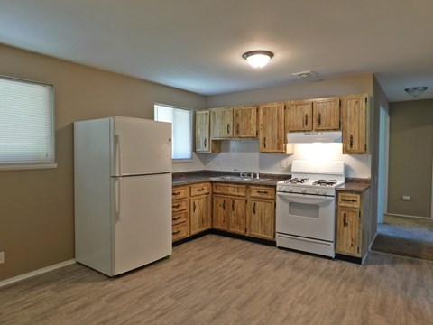 A kitchen with wooden cabinets and a white refrigerator.