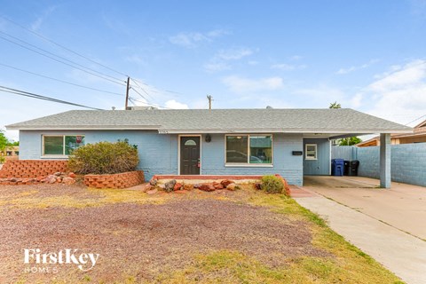 the front of a blue house with a driveway