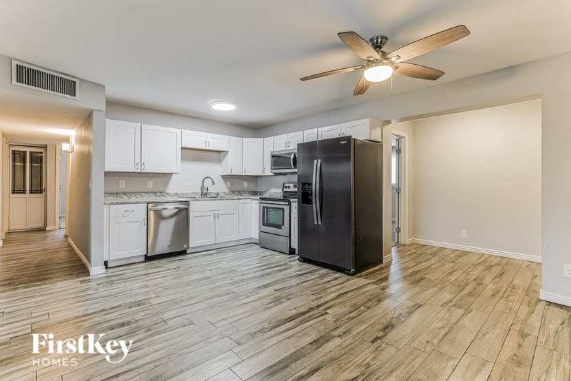 a kitchen with white cabinets and a black refrigerator