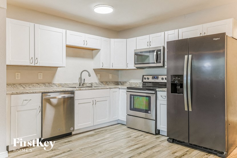 a kitchen with stainless steel appliances and white cabinets