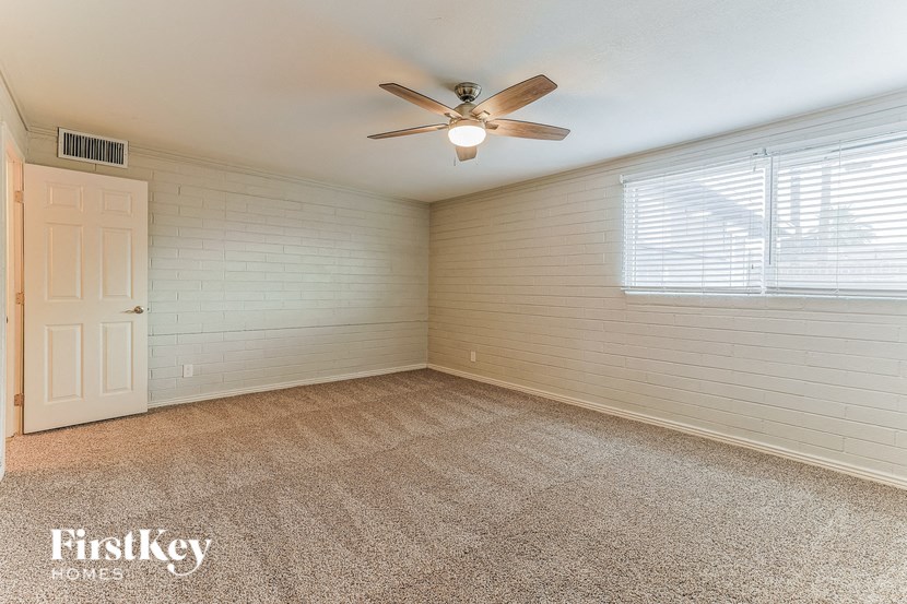 an empty room with a ceiling fan and a window