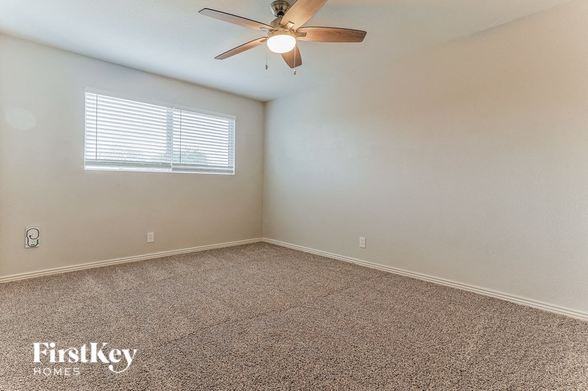 an empty room with a ceiling fan and a window