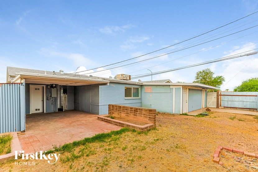 a small blue house with a brick porch and a garage