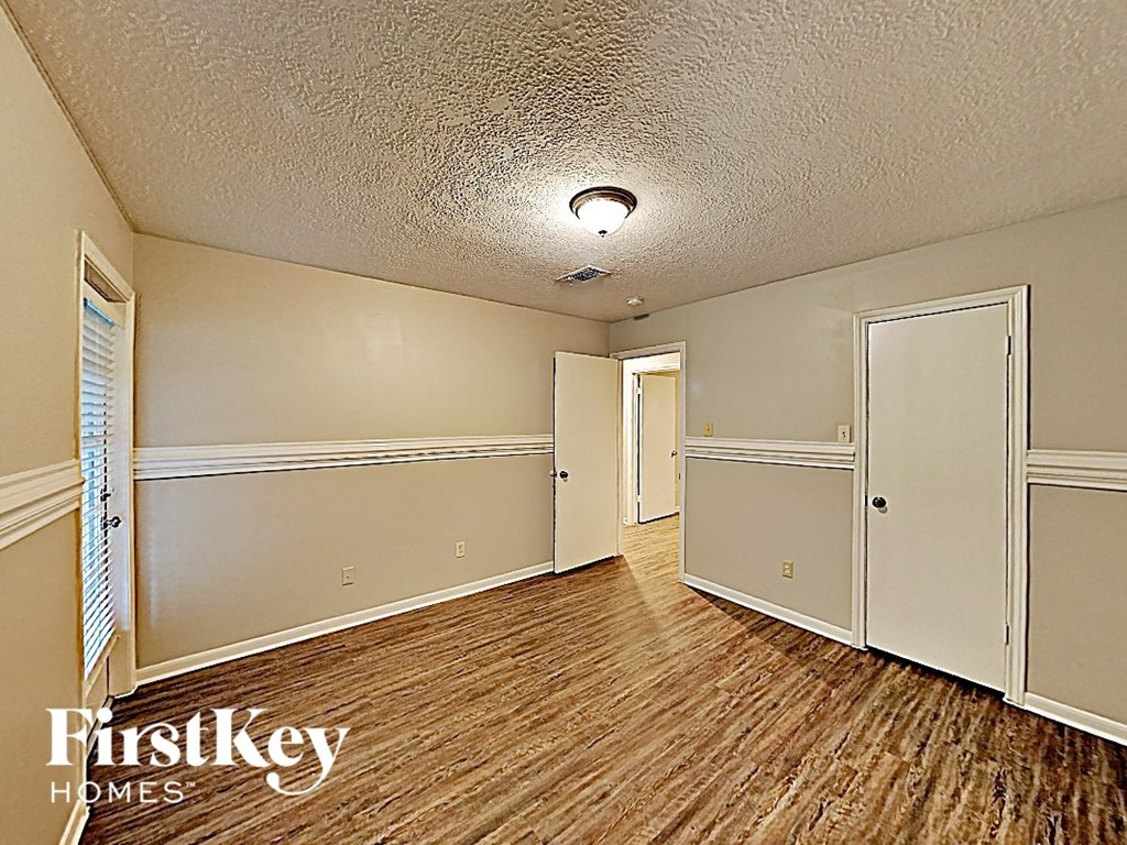 an empty living room with wood flooring and white walls