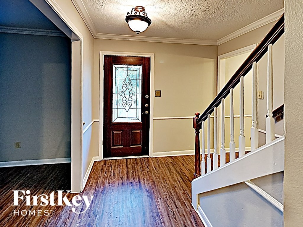 the entryway of a house with a wooden door and stairs