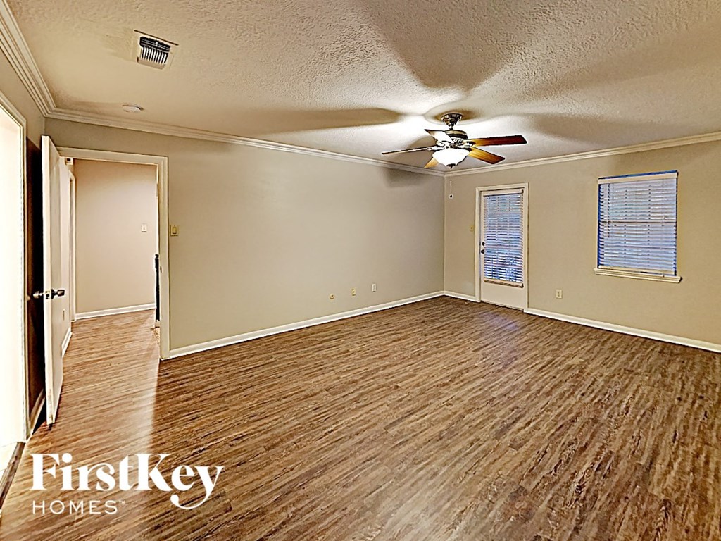 the living room of an empty house with a ceiling fan