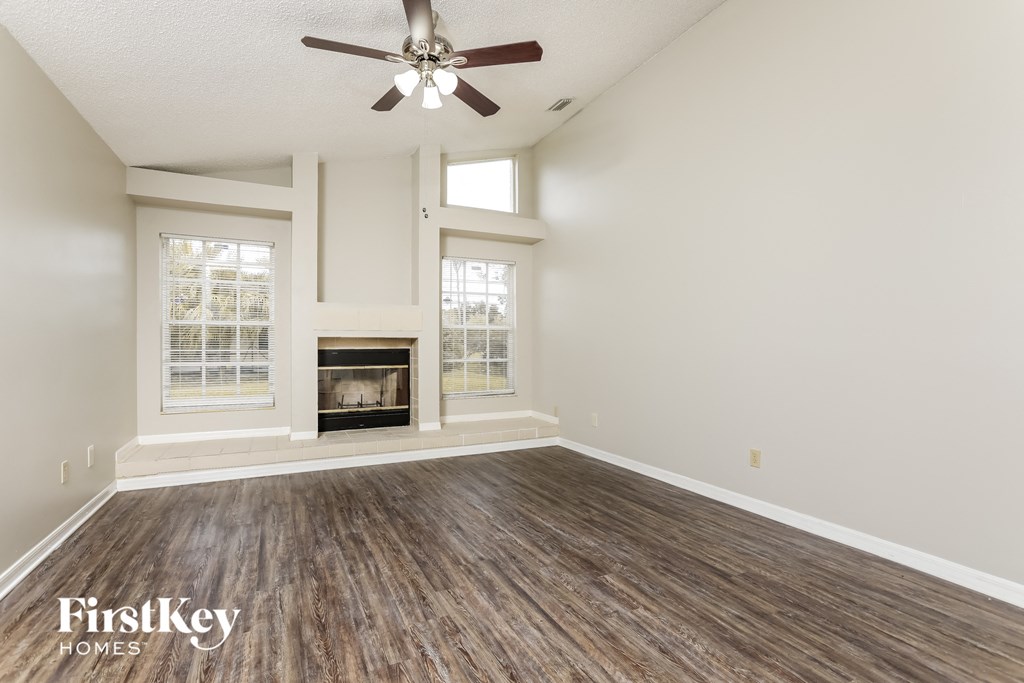 A room with a fireplace and a ceiling fan.