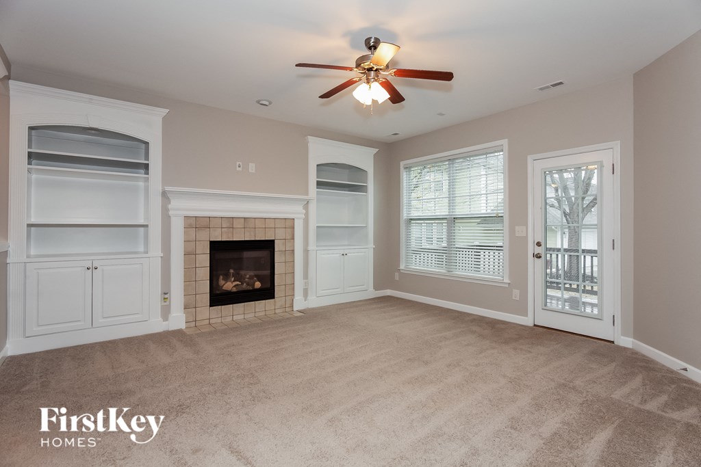 a living room with a fireplace and a ceiling fan