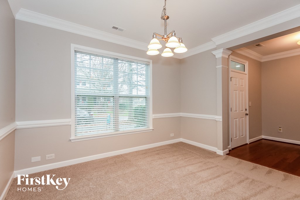 a dining room with a large window and a white door