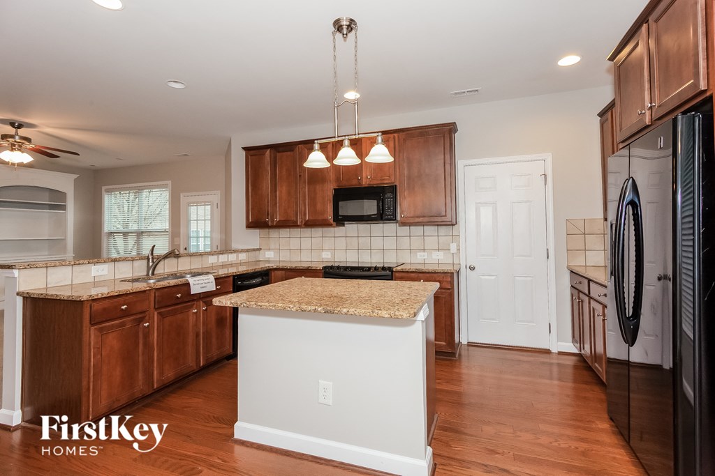 a kitchen with wooden cabinets and a white island with granite counter tops