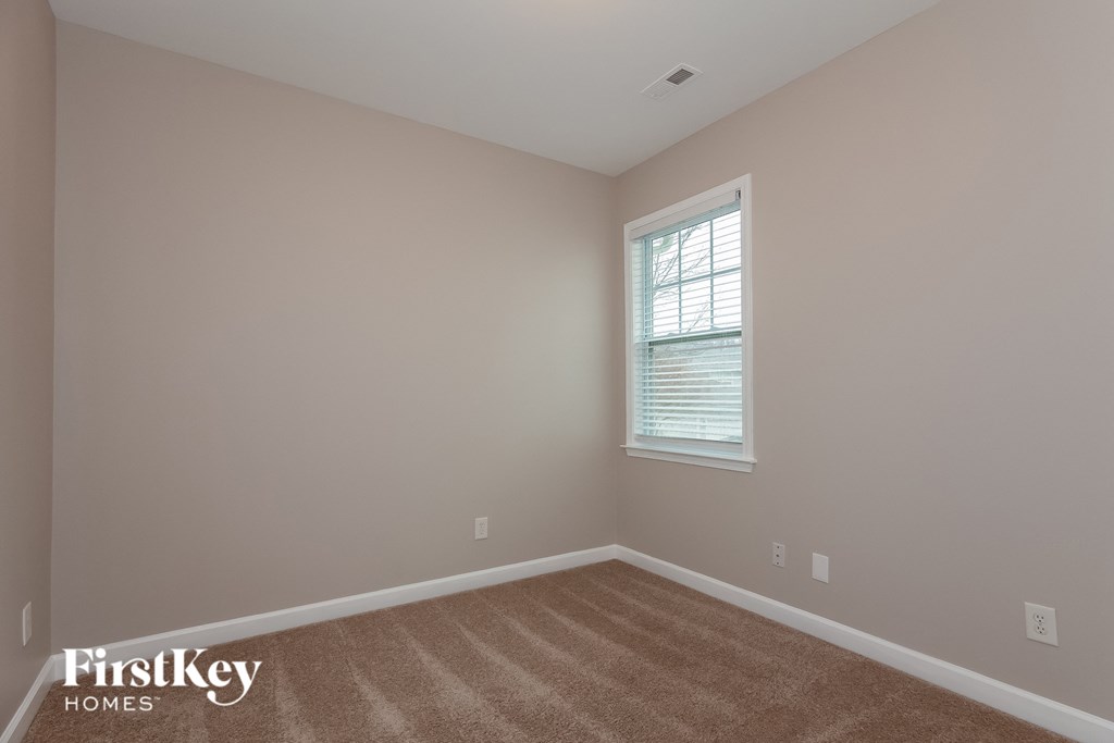 the second bedroom with carpet and a window
