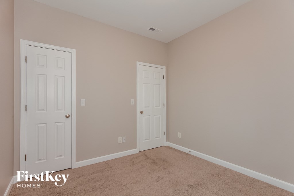 a bedroom with two doors and a carpeted floor