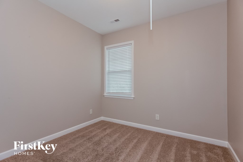 the upstairs bedroom with carpet and a window