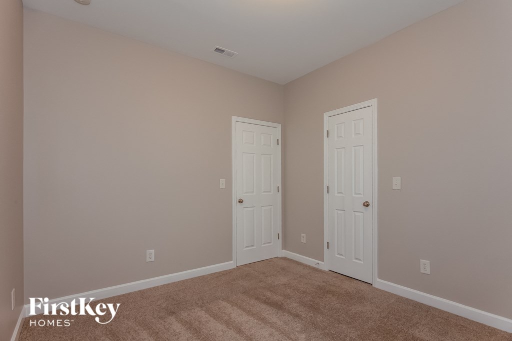 a bedroom with two doors and a carpeted floor