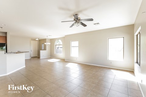 A spacious room with a ceiling fan and tiled flooring.